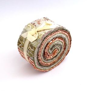 Könnte beinhalten: Eine Rolle Stoffreste in Grün-, Braun- und Cremetönen, gebunden mit einem cremefarbenen Band. Der Stoff ist mit verschiedenen Mustern bedruckt.