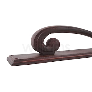 May include: A dark brown cast iron door handle with a decorative scroll design. The handle is mounted on a rectangular base.