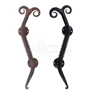 May include: Two door handles with a unique design. One is a rusty brown color and the other is black. Both handles have a spiral design and a curved top.