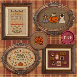 May include: A collection of framed cross-stitch samplers with a Halloween theme. The samplers include a jack-o'-lantern, a witch, a cat in a pumpkin costume, and the words "Home Sweet Home". The frames are ornate and brown.