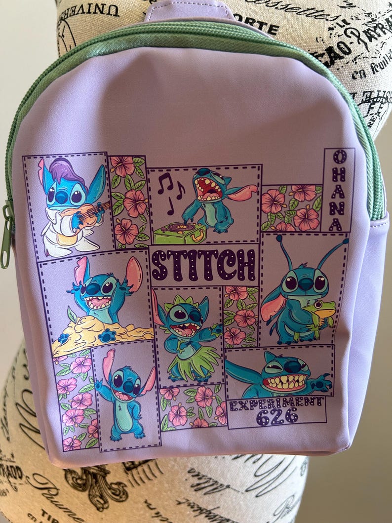 May include: Purple backpack with a green zipper and a patchwork design featuring Stitch from Lilo & Stitch. The design includes Stitch playing music, hula dancing, and holding a frog. The text "Stitch" and "Ohana" are included in the design.