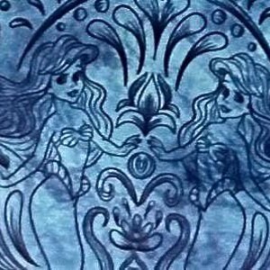 May include: A blue illustration featuring two mermaids facing each other, their hands almost touching. The artwork has a symmetrical design with floral and water-like elements, creating a whimsical and aquatic theme.