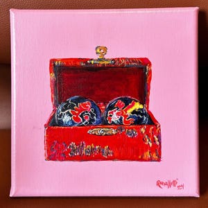 May include: A square canvas painting depicts a red chest containing two blue and red decorative spheres. The chest is open, revealing a red interior. The background is a solid pink colour.
