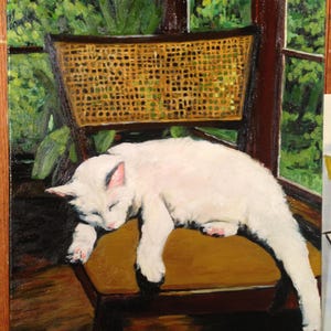 Könnte beinhalten: Ölgemälde einer weißen Katze, die auf einem Stuhl mit gewebtem Rücken schläft. Die Katze liegt auf einem senffarbenen Kissen. Der Hintergrund zeigt ein Fenster mit grünem Laub und einem Holzrahmen.