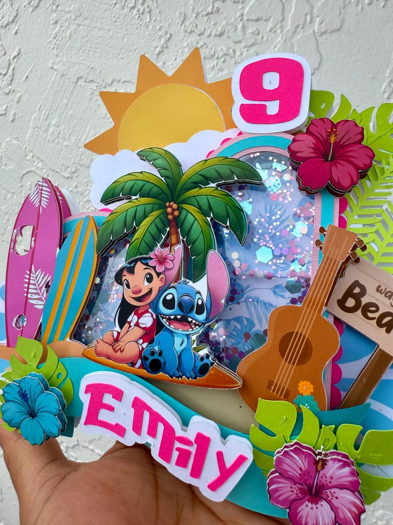 May include: A vibrant, layered birthday decoration with Lilo and Stitch, a palm tree, a ukulele, and a sign that says "Beach". The number 9 is displayed, along with the name "Emily". Decorative hibiscus flowers and surfboards complete the tropical theme.