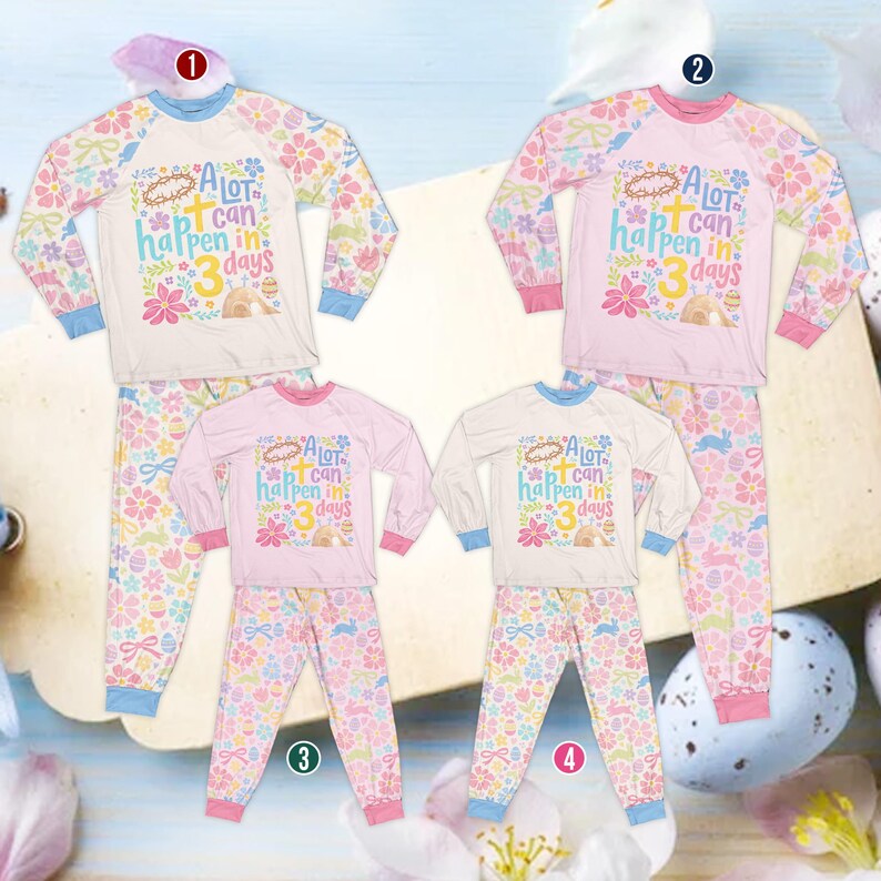 Op de afbeelding: Vier sets paajamas met Pasen-thema. Elke set bevat een top met lange mouwen en een bijpassende broek. De tops zijn wit of roze met de tekst "A lot can happen in 3 days". De broeken hebben bloemen- en paasei-patronen.