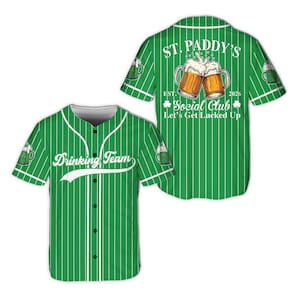 Pode incluir: Camisola de baseball verde com riscas brancas e as palavras "Drinking Team" em branco. A parte de trás da camisola apresenta o texto "St. Paddy's Social Club" com duas canecas de cerveja e a frase "Let's Get Lucked Up".