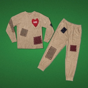 May include: A long-sleeve shirt and pants set in a tan burlap-textured print featuring dark brown and black rectangular patches with visible stitching. The shirt includes a red heart graphic on the chest with the white text NAME printed inside.