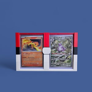 May include: A white, red, and black card display case holding two Pokémon trading cards. The cards feature Moltres and Nidoking. The case has a rectangular shape with a central divider and a blue background.