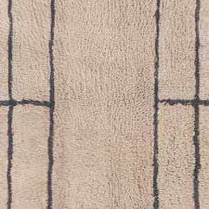 Tan Moroccan wool runner rug featuring a layered double border in charcoal gray. Hand-knotted by Berber artisans in the Beni Ourain style using 100% sheep wool, this soft and thick rug is perfect for long hallways, kitchen walkways, or narrow transitional zones. The modern geometric framing adds symmetry and visual structure to minimalist interiors. A durable, artisan-made wool runner ideal for Japandi, Scandinavian, or contemporary home styling.