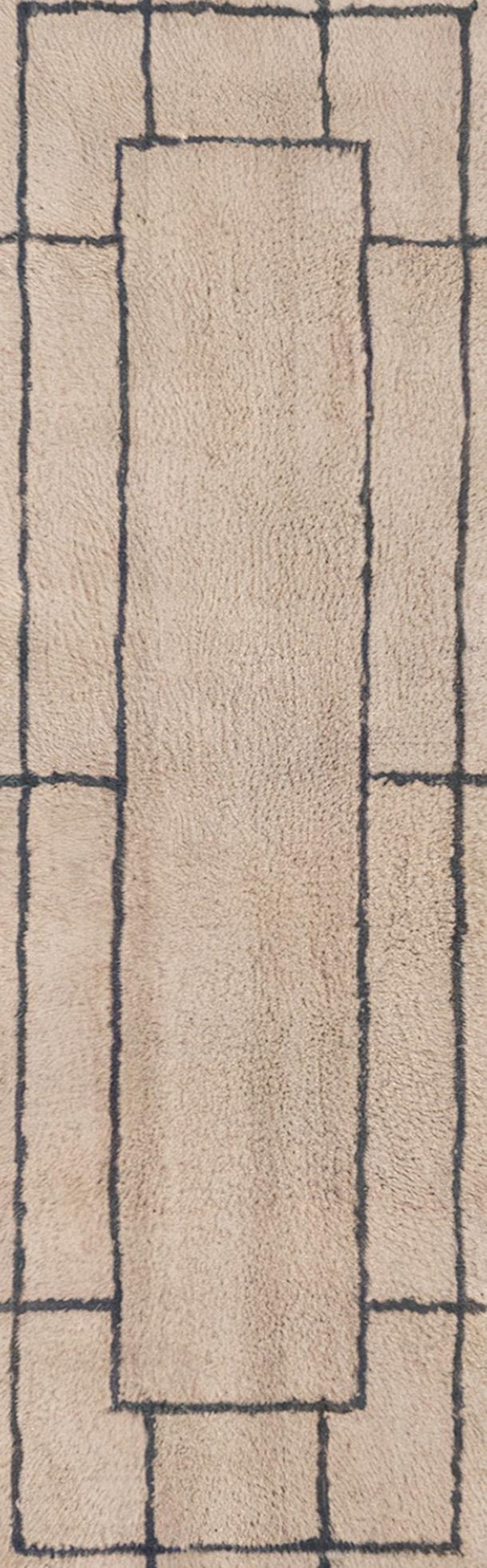 Tan Moroccan wool runner rug featuring a layered double border in charcoal gray. Hand-knotted by Berber artisans in the Beni Ourain style using 100% sheep wool, this soft and thick rug is perfect for long hallways, kitchen walkways, or narrow transitional zones. The modern geometric framing adds symmetry and visual structure to minimalist interiors. A durable, artisan-made wool runner ideal for Japandi, Scandinavian, or contemporary home styling.