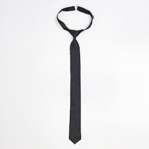 Smal slips i svart ull med tryckknappsdesign