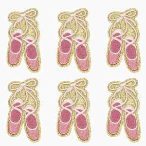 May include: Six embroidered patches of pink ballet slippers with light pink ribbons and gold glitter borders. Each patch features a pair of ballet shoes tied together with a bow. The patches are arranged in two rows of three.