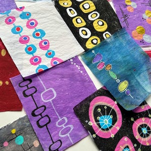 Peut inclure: Une collection d'&oelig;uvres d'art abstraites color&eacute;es. Chaque pi&egrave;ce pr&eacute;sente des motifs uniques avec diverses formes et couleurs, notamment le bleu, le rose, le jaune et le violet. Les &oelig;uvres d'art sont sur fond blanc.