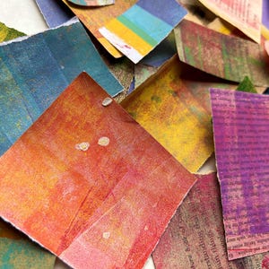 May include: A collection of colorful paper scraps with various textures and patterns. Some of the scraps have text printed on them, including the words "The Adventure" and "Wash the".