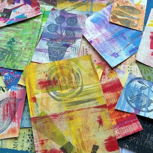 May include: A collection of rectangular paper scraps featuring mixed media art with various prints, including a potted plant, a bird, fish, and a mushroom. The pieces display vibrant layers of yellow, green, blue, and red paint with visible text.