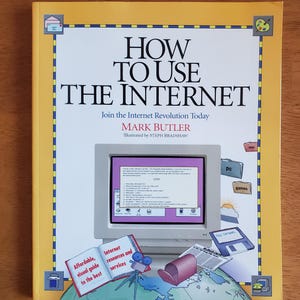 May include: A book titled "HOW TO USE THE INTERNET" with a yellow border. The cover features a computer monitor displaying text, along with illustrations of a globe, a floppy disk, and other computer-related items. The author is Mark Butler.