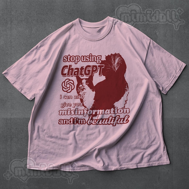 May include: A light pink t-shirt with a graphic of a cat and text that reads "stop using ChatGPT, I can also give you misinformation and I'm beautiful."