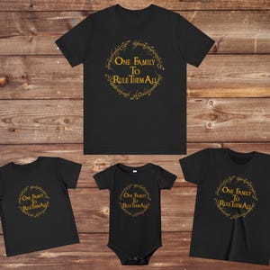 Könnte beinhalten: Set aus vier schwarzen T-Shirts mit einer goldenen Grafik eines Rings mit dem Text "One Family To Rule Them All".