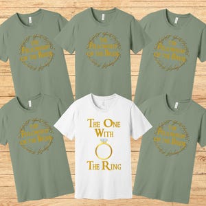 May include: Five green t-shirts with gold text and graphics. The shirts feature the text "The Fellowship of the Ring" and "The One With The Ring".