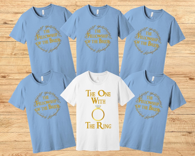 May include: Set of six light blue t-shirts with gold text and graphics. The shirts feature the text "The Fellowship of the Bride" and "The One with the Ring".
