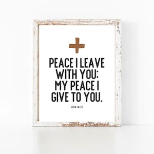 Può includere: Una stampa incorniciata bianca con una croce marrone in alto e il testo "PEACE I LEAVE WITH YOU: MY PEACE I GIVE TO YOU. JOHN 14:27"