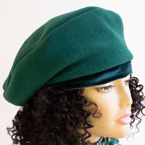 Peut inclure: Un béret vert foncé avec une bordure en velours. Le béret est fait d'un matériau doux, semblable au feutre.