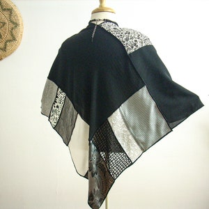K&ouml;nnte beinhalten: Ein schwarz-wei&szlig;es Patchwork-Poncho mit geometrischem Muster. Das Poncho besteht aus verschiedenen Stoffen, darunter Mesh, Spitze und Satin.