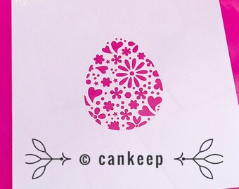 May include: A white stencil with a pink background featuring a floral and heart patterned Easter egg design. The stencil includes the text "© cankeep" at the bottom.