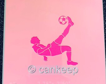 May include: Pink stencil featuring a soccer player performing a bicycle kick, with a soccer ball. The stencil has the text "cankeep" and the dimensions 2.75" x 2.60". The stencil is pink with a darker pink border.