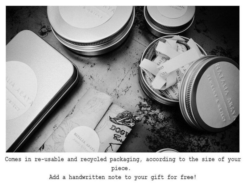 May include: Black and white image featuring several small, round metal tins and a rectangular tin. Some tins are open, revealing paper scraps. The image also shows rolled-up paper and text that reads "NATALIA ARAYA" and "DOGY Cor".