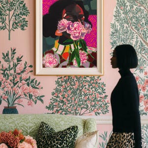 May include: A framed art print featuring a stylized portrait of a person with dark skin and hair, their face partially obscured by a cluster of pink peony flowers. The background uses vibrant magenta, dark green, and geometric patterns in a bold style.