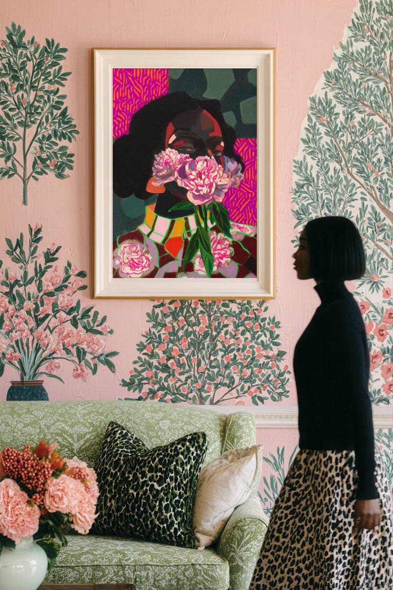 May include: A framed art print featuring a stylized portrait of a person with dark skin and hair, their face partially obscured by a cluster of pink peony flowers. The background uses vibrant magenta, dark green, and geometric patterns in a bold style.