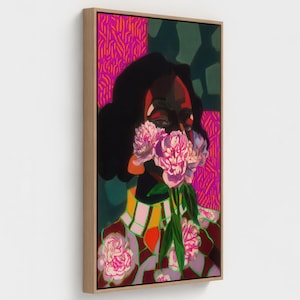 May include: A natural framed canvas featuring a vibrant painting of a figure with dark skin holding a bouquet of pink peonies over their face. The artwork includes bold patterns in magenta, dark green, and yellow, with a light wood frame border.