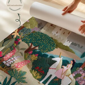 May include: An unframed print with a digital embroidery effect, featuring a fantasy scene. A woman in a pink dress rides a white unicorn through a colorful landscape with a castle in the background. The print is partially rolled up, revealing the back.