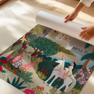 May include: A colorful, embroidered tapestry featuring a unicorn with a rider, set in a whimsical landscape with flowers, trees, and a castle. The tapestry is being unrolled, revealing the detailed artwork.