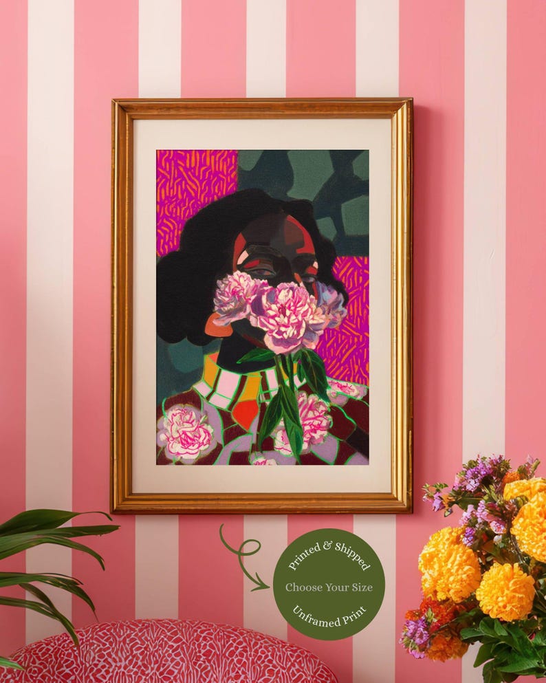 May include: A framed art print featuring a stylized portrait of a person with dark skin, holding a cluster of pink peonies over their face. The artwork uses vibrant colors, including magenta, orange, and deep green, with a patterned background.