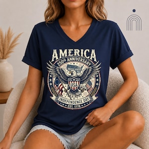 May include: Navy blue V-neck t-shirt featuring a patriotic design for the 250th Anniversary of Independence Day. The graphic includes an eagle, the USA map, and the text "America" and "Independence Day".