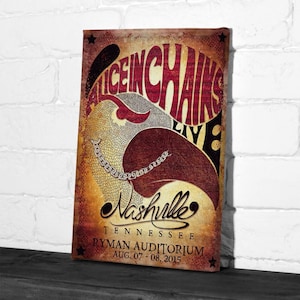 May include: A vintage-style poster for the band Alice in Chains Live in Nashville, Tennessee. The poster features the band's name in a large, stylized font, with a graphic of a bird or creature. The poster includes the Ryman Auditorium and the date.