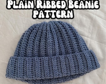 Könnte beinhalten: Eine blaue gehäkelte Mütze mit vertikaler Rippenstruktur und umgeschlagenem Rand. Der Text PLAIN RIBBED BEANIE PATTERN ist in weißen Buchstaben mit schwarzer Umrandung über der Mütze zu sehen, die ein gleichmäßiges Strickmuster aufweist.