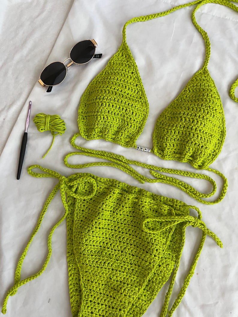 May include: Lime green crochet bikini top and bottom with adjustable straps. The top has a small metal charm that says "DEAL".