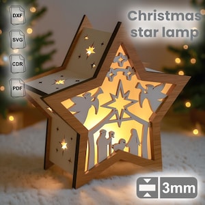Peut inclure: Une lampe étoile de Noël en bois avec un intérieur chaleureux et lumineux. La lampe en forme d'étoile présente des motifs découpés d'étoiles, d'anges et d'une scène de la Nativité. Le texte "Christmas star lamp" est visible. L'épaisseur de la lampe est de 3 mm.