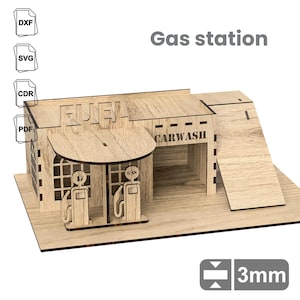 Può includere: Un kit di modellismo in legno di una stazione di servizio con un autolavaggio, due distributori di benzina e un cartello che dice "FUEL". Il modello è spesso 3 mm e viene fornito con istruzioni di montaggio.