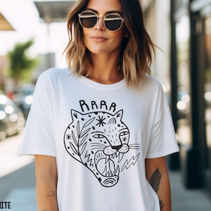 May include: White t-shirt with a black and white illustration of a roaring jaguar with the word "RAWR" above it.