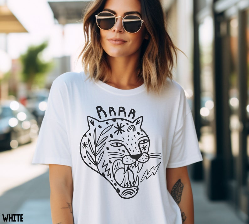 May include: White t-shirt with a black and white illustration of a roaring jaguar with the word "RAWR" above it.