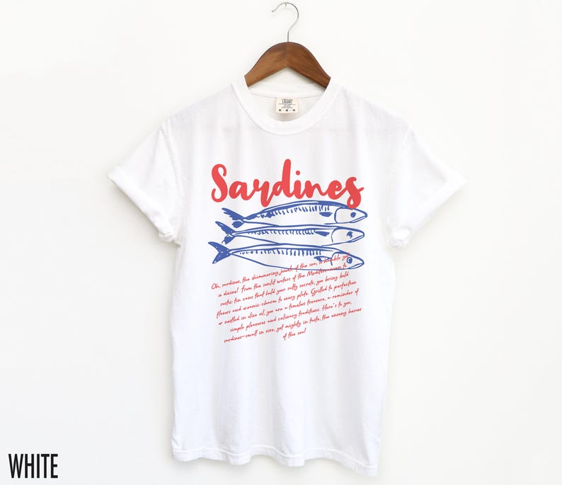 May include: White t-shirt with a red and blue graphic of sardines and text that reads "Sardines" and "Oh, sardines, the shimmering jewels of the sea... you are a treasure from the wild waters of the Atlantic..."