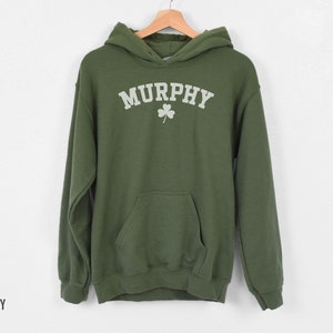May include: A green hooded sweatshirt with the word "MURPHY" in white lettering and a white shamrock design.