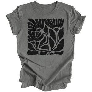 May include: A gray t-shirt with a black floral print. The print features stylized flowers and leaves in a blocky design.