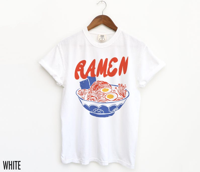May include: White t-shirt featuring a red graphic of a bowl of ramen noodles. The text "RAMEN" is printed in red above the bowl.