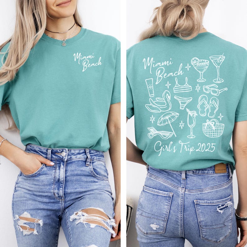 May include: A teal blue t-shirt with the text "Miami Beach" on the front and a design of beach-themed items and the text "Girls Trip 2025" on the back.